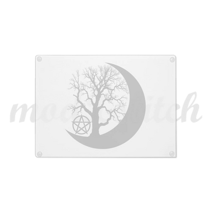 Beautiful glass cutting board with a tree silhouette inside a crescent moon on a white background.  Perfect for witches and wiccans
